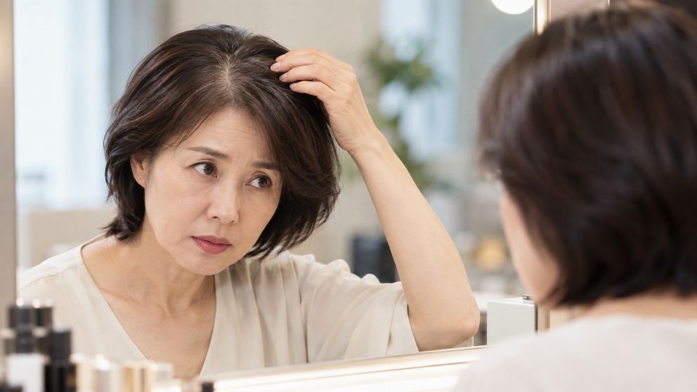 정수리 숱이 줄어든 50대 여성이 짧은 헤어스타일과 볼륨을 확인하는 모습